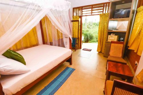 a bedroom with a bed with a mosquito net at Milkyway Holiday Resort in Unawatuna