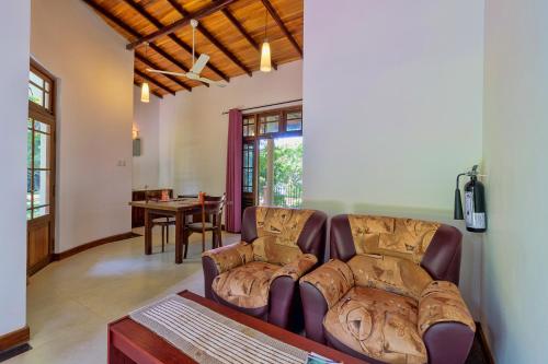 a living room with a couch and a table at Hotel Sobana Lake front in Udawalawe