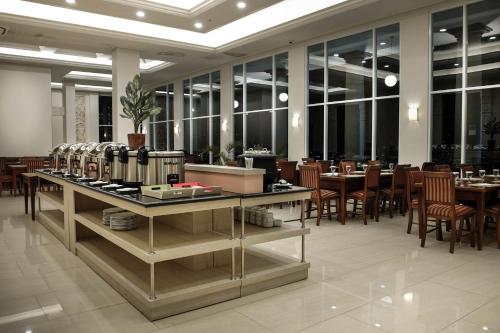a dining room with tables and chairs and windows at Onih Hotel in Bogor