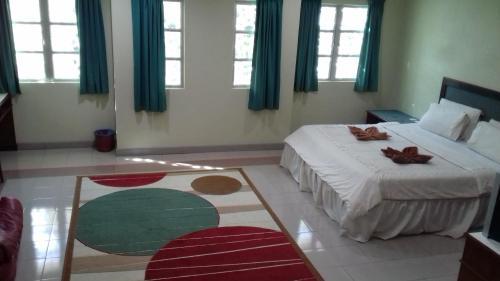 a bedroom with a bed with two shoes on it at Arwana Inn Tok Bali in Pasir Puteh