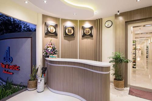 a lobby with a counter with clocks on the wall at The Xotic Jimbaran Bali in Jimbaran