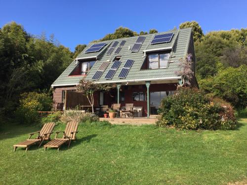 una casa con paneles solares en el techo en The Beach Lodge, en Onekaka