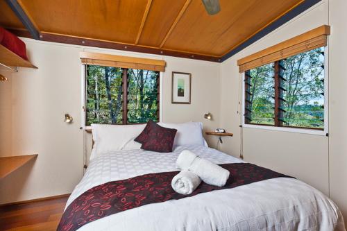 a bedroom with a large bed with towels on it at Rosebrook Cottages in Maleny