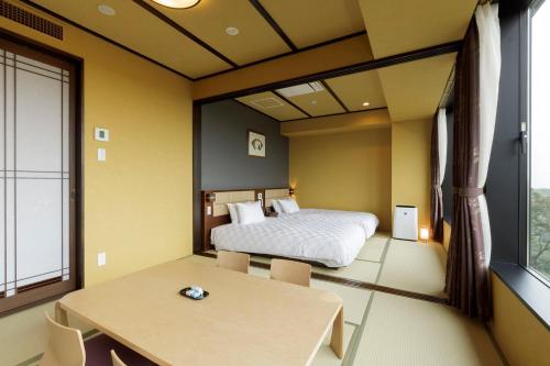 a bedroom with a bed and a table and a table sidx sidx sidx at Hotel Mori no Kaze Nasu in Nasu