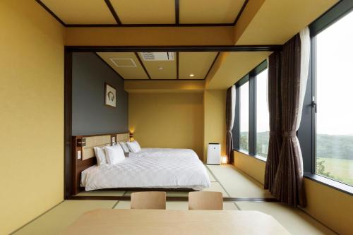 a bedroom with a bed and a large window at Hotel Mori no Kaze Nasu in Nasu