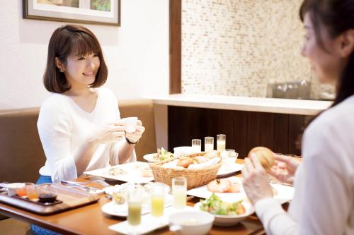 a woman sitting at a table eating food at Hotel Mori no Kaze Nasu in Nasu