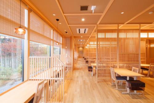 a cafeteria with tables and chairs and large windows at Hotel Mori no Kaze Nasu in Nasu