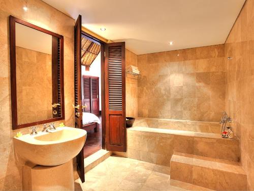 a bathroom with a sink and a tub at Villa Alamanda in Ubud