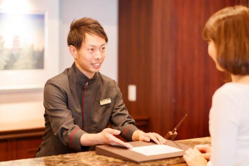 a man and a woman sitting at a table with a laptop at Hotel Mori no Kaze Nasu in Nasu