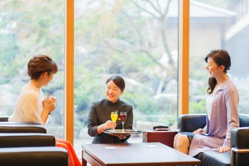 a group of people sitting around a table in a restaurant at Hotel Shiki no Yakata Nasu in Nasu