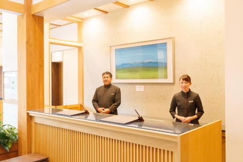 a couple of men standing behind a counter at Hotel Shiki no Yakata Nasu in Nasu