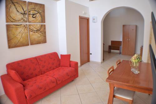 a living room with a red couch and a table at Borgo Saraceno in Spinazzola