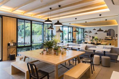 een eetkamer met een grote houten tafel en stoelen bij The Journey Hotel Laksi in Bangkok