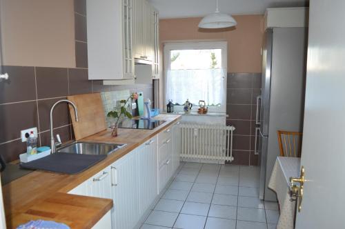 uma cozinha com armários brancos, um lavatório e uma janela em Seglerhafen em Ahrensbök