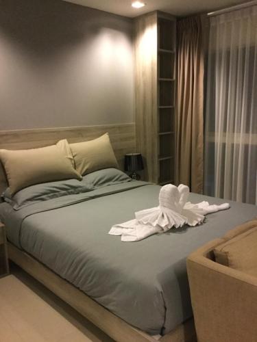 a bedroom with a bed with a white towel on it at Grand Blue Condominium by Mary in Mae Pim