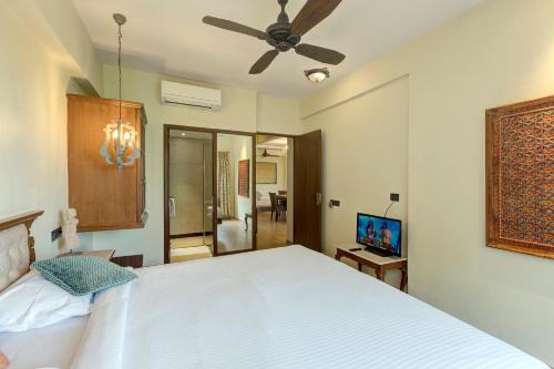 a bedroom with a white bed and a ceiling fan at Ramsukh Resorts and Spa in Mahabaleshwar