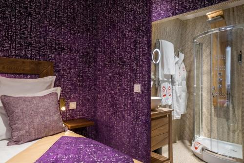 a purple room with a bed and a bathroom at Le Temple De Jeanne in Paris