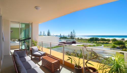 balcón con sofá y vistas al océano en Kirra Surf Apartments, en Gold Coast