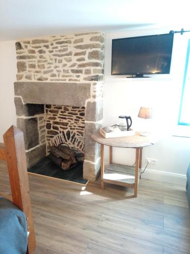 a living room with a stone fireplace and a table at Frenes B&B in Frênes