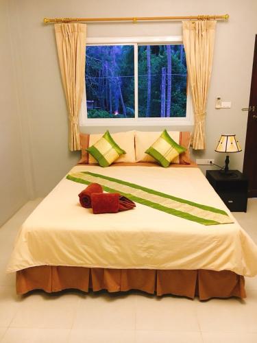 a bedroom with a large bed with a window at Bussarin Mansion Koh Yao Yai in Ko Yao Yai