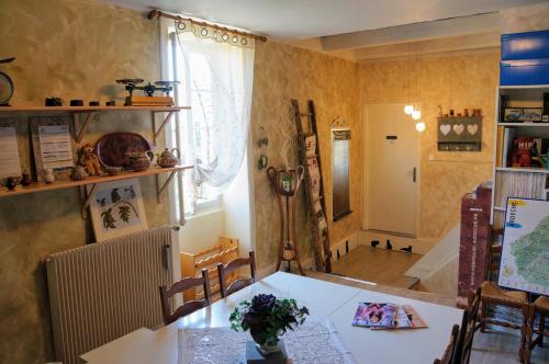 une salle à manger avec une table et des chaises ainsi qu'un couloir dans l'établissement Maison du Manoir, à Vallon-Pont-dʼArc