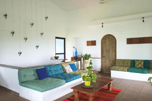 a living room with a couch and a table at Bungalow 89 by StayVista - A hill-view villa adorned with eclectic interiors for a truly unique & captivating stay in Lonavala
