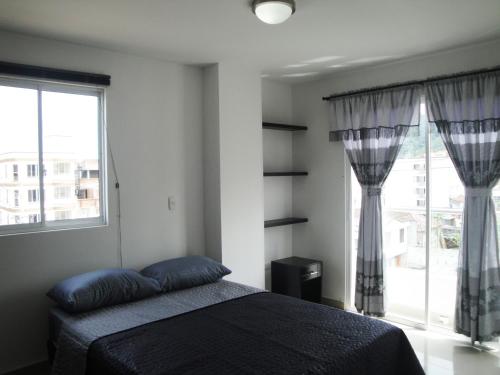 a bedroom with a bed and a large window at Santa Isabel Centro 401 in Santa Rosa de Cabal