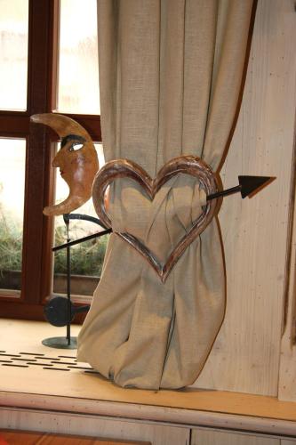 a sculpture of a heart with an arrow in a window at Hotel Goldener Stern in Frauenstein