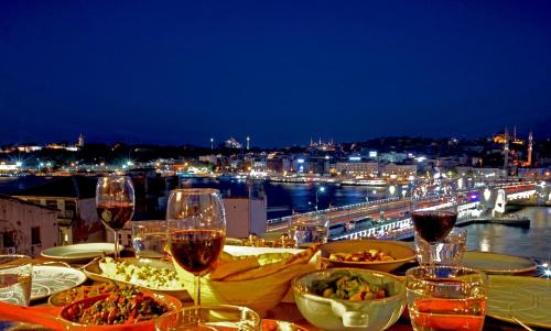 a table with wine glasses and food and a view of a city at Hotel Momento Golden Horn in Istanbul