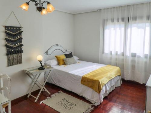 a white bedroom with a bed and a window at EL ALJEZAR in Teruel