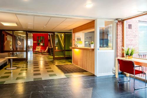 vestíbulo de un edificio con sillas y mesas en Västerbacken Hotell & Konferens, en Holmsund