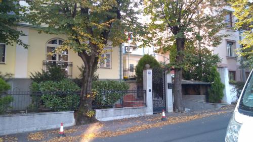 a house with a gate and two trees on a street at Resident hill resort in Belgrade