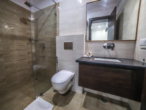 ein Bad mit einem WC, einem Waschbecken und einer Dusche in der Unterkunft Adya Inn in Jodhpur