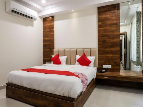 a bedroom with a large bed with red pillows at Adya Inn in Jodhpur