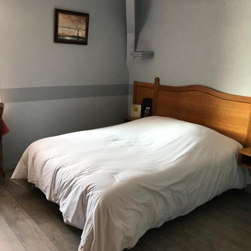 Ένα ή περισσότερα κρεβάτια σε δωμάτιο στο Logis Hôtel & Restaurant - Le Normandie