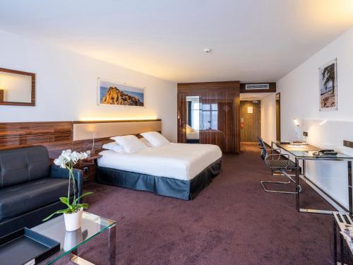 une chambre d'hôtel avec un lit et un canapé dans l'établissement Westotel Le Pouliguen, au Pouliguen