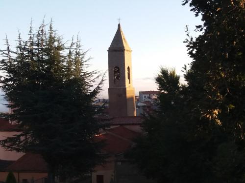a church steeple with a clock tower in a city at Locanda 130 in Fonni