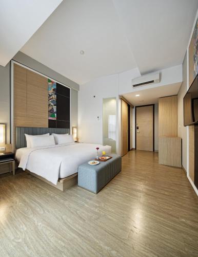 a bedroom with a large white bed and a couch at MaxOne Platinum Hayam Wuruk in Jakarta