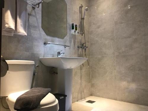 a bathroom with a sink and a toilet at Hotel Arisu in Serang