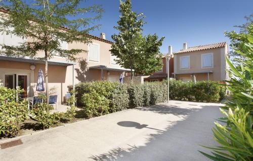 a driveway in front of a house at Résidence Odalys Le Mas des Flamants in Aigues-Mortes