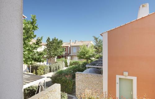 an alley between two buildings with a green door at Résidence Odalys Le Mas des Flamants in Aigues-Mortes