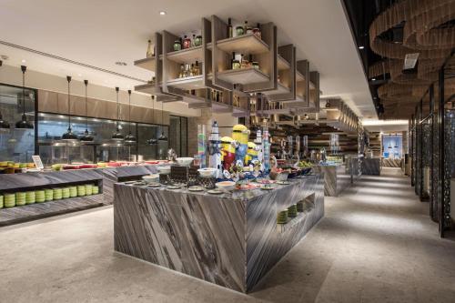 a restaurant with a counter in the middle of a room at 三亚鹿回头蔚景温德姆酒店 in Sanya