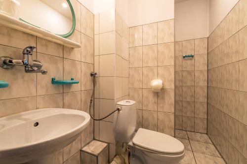 uma casa de banho com um WC branco e um lavatório. em Savoy Wrocław em Breslávia