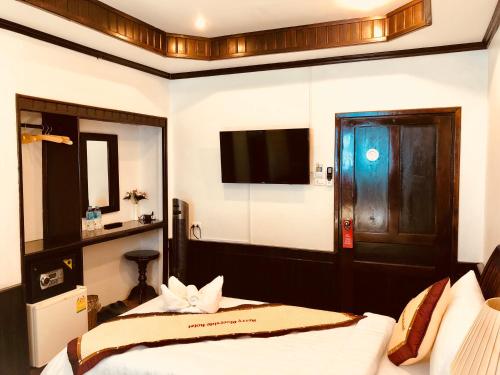 a hotel room with a bed and a television at Merry Riverside Hotel in Luang Prabang