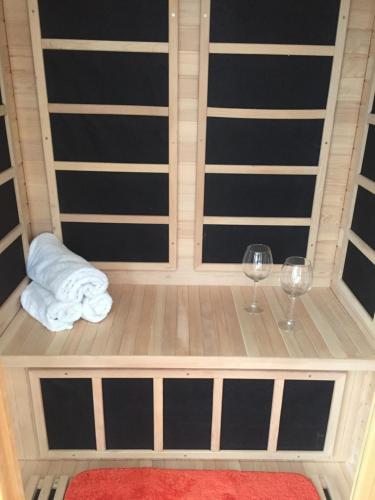 a bed with two wine glasses and a towel at Scaurbridge Cottage with Hot Tub and Sauna in Thornhill