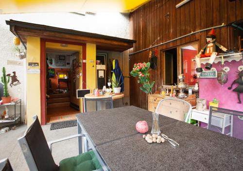 eine Küche mit einem Tisch und ein Zimmer mit einem Haus in der Unterkunft Bed&Breakfast Pinocchio in Seuzach