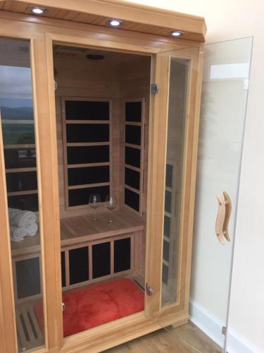 a room with a closet with a glass door at Scaurbridge Cottage with Hot Tub and Sauna in Thornhill