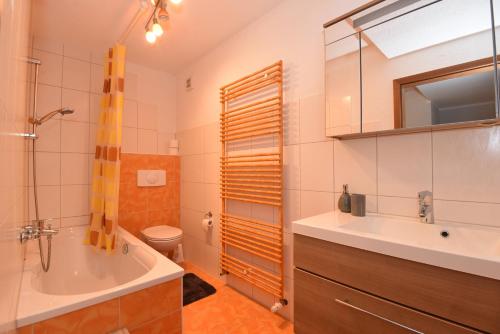 a bathroom with a tub and a sink and a toilet at Ferienwohnung Schulze in Ilmtal