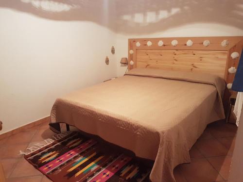una camera con letto e testiera in legno di Casa Vacanze Marausa Birgi KITE a Marausa
