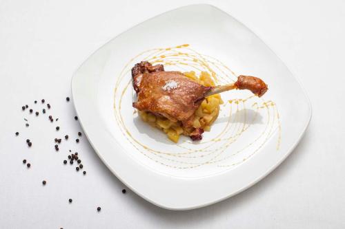 a plate with a piece of food on top of pasta at Hostal La Plaça in Erill la Vall